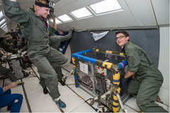 Jessica Vos (left, NASA) floats to the ceiling and Roman Kowalchuk (right, Duke University) poses after taking measurements of corneal deformation characteristics in microgravity. Photo: NASA